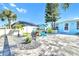 Landscaped backyard featuring stone pavers, colorful Adirondack chairs, lush plants, and a fenced in pool at 1015 Spindle Palm Way, Apollo Beach, FL 33572