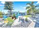 Charming home features a spacious backyard with a fire pit, outdoor seating, lush plants, and a water view at 1015 Spindle Palm Way, Apollo Beach, FL 33572