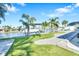 Beautiful waterfront backyard with manicured lawn, lush tropical foliage, and boat dock with lift at 1015 Spindle Palm Way, Apollo Beach, FL 33572