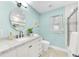 Bright bathroom featuring vanity, a round mirror, and tiled walk-in shower with glass door at 1015 Spindle Palm Way, Apollo Beach, FL 33572