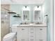 Bright bathroom with dual sinks, modern lighting, and a tiled shower with a glass door at 1015 Spindle Palm Way, Apollo Beach, FL 33572