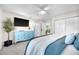 Bright bedroom with a large closet, blue dresser, TV, and a cozy bed at 1015 Spindle Palm Way, Apollo Beach, FL 33572