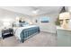 Cozy bedroom with a blue metal bed frame, plush carpet, and lots of natural light at 1015 Spindle Palm Way, Apollo Beach, FL 33572