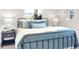 Bedroom with a blue metal bed frame, natural light, and a classic nightstand at 1015 Spindle Palm Way, Apollo Beach, FL 33572