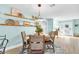 Bright dining room with a round table, decoratively shelved walls, and access to the front entry and living areas at 1015 Spindle Palm Way, Apollo Beach, FL 33572