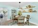 Charming dining room with a round table, stylish decor, open shelving, and a view into the living spaces at 1015 Spindle Palm Way, Apollo Beach, FL 33572