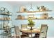 Cozy dining area featuring a round table, decorative shelving, and views into the living and dining areas at 1015 Spindle Palm Way, Apollo Beach, FL 33572