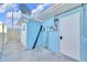 Bright blue house with concrete patio and exterior doors at 1015 Spindle Palm Way, Apollo Beach, FL 33572