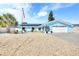 Charming coastal home with an attached garage, solar panels, palm trees, and gravel landscaping at 1015 Spindle Palm Way, Apollo Beach, FL 33572