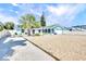 Charming home with gravel landscaping, mature palms and an arched entryway with solar panels at 1015 Spindle Palm Way, Apollo Beach, FL 33572