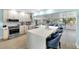 Bright, updated kitchen features modern appliances, light wood cabinets, quartz countertops, and breakfast bar seating at 1015 Spindle Palm Way, Apollo Beach, FL 33572