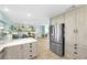 Modern kitchen with stainless steel refrigerator, light wood cabinets, and breakfast bar overlooking dining area at 1015 Spindle Palm Way, Apollo Beach, FL 33572
