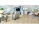 Open-concept living room with a modern design, wood floors, blue accent wall, and a view into the kitchen and dining areas at 1015 Spindle Palm Way, Apollo Beach, FL 33572
