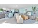 Spacious living room with an open floor plan, light blue walls, bar seating, and a cozy sitting area at 1015 Spindle Palm Way, Apollo Beach, FL 33572