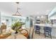 Open living space featuring a dining area, kitchen with island seating, and views into the living room at 1015 Spindle Palm Way, Apollo Beach, FL 33572