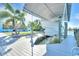 View of a bright blue waterfront property with a boat lift and beautifully landscaped yard at 1015 Spindle Palm Way, Apollo Beach, FL 33572