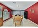 Open dining room has hardwood floors, bright window, stylish light fixture and grey and red walls at 11257 Persimmon Ave, Weeki Wachee, FL 34614