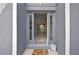 Inviting entryway of gray home with a decorative 'hello' mat and views into the living and dining areas at 11257 Persimmon Ave, Weeki Wachee, FL 34614