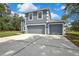 Two-story gray home featuring white trim accents and a spacious driveway leading to attached two-car garage at 11257 Persimmon Ave, Weeki Wachee, FL 34614