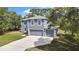 Two-story home featuring gray exterior, white trim, double garage and mature landscaping at 11257 Persimmon Ave, Weeki Wachee, FL 34614