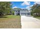 Two-story home boasting a gray exterior, white trim, double garage, and mature landscaping at 11257 Persimmon Ave, Weeki Wachee, FL 34614