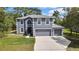 Two-story home with gray exterior, white trim, double garage and mature landscaping at 11257 Persimmon Ave, Weeki Wachee, FL 34614