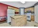 Well-equipped kitchen with a central island, white appliances, and wooden cabinetry at 11257 Persimmon Ave, Weeki Wachee, FL 34614