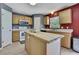 Functional kitchen featuring an island, white appliances, and ample cabinet space at 11257 Persimmon Ave, Weeki Wachee, FL 34614
