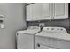 Functional laundry room with a modern washer and dryer, complemented by upper cabinets at 11257 Persimmon Ave, Weeki Wachee, FL 34614
