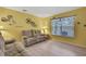 Comfortable living room with bright yellow walls, plush sofas, and whimsical Disney-themed decor at 11257 Persimmon Ave, Weeki Wachee, FL 34614