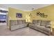 Bright living room showcasing light hardwood floors, cozy sofas, and unique Disney-themed wall art at 11257 Persimmon Ave, Weeki Wachee, FL 34614