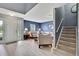 Bright living room showcases a staircase, light wood flooring, and neutral-toned furniture at 11257 Persimmon Ave, Weeki Wachee, FL 34614