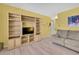 Bright living room featuring built-in shelving, a TV, light hardwood floors, and a comfy sofa at 11257 Persimmon Ave, Weeki Wachee, FL 34614