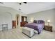 Primary bedroom with a ceiling fan, light floors, and a comfortable purple bed at 11257 Persimmon Ave, Weeki Wachee, FL 34614