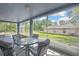 Inviting screened-in porch with table and chairs, perfect for enjoying the outdoor scenery at 11257 Persimmon Ave, Weeki Wachee, FL 34614