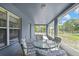 Cozy screened-in porch featuring outdoor seating and a peaceful view of the surrounding landscape at 11257 Persimmon Ave, Weeki Wachee, FL 34614
