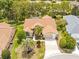 Aerial view of home with a brown roof, driveway, two car garage, and palm trees at 11284 Hickory Ridge Ct, Spring Hill, FL 34609