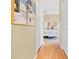 Hallway view leading to bedroom with hardwood floors, white doors, and a decorative painting at 11284 Hickory Ridge Ct, Spring Hill, FL 34609