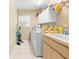 A laundry room view with white cabinets, washer, dryer and a utility sink at 11284 Hickory Ridge Ct, Spring Hill, FL 34609