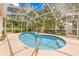 A screened-in pool with chrome handrails provides an easy entry point for accessibility at 11284 Hickory Ridge Ct, Spring Hill, FL 34609