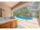 Relaxing screened-in pool area with a hot tub and lush greenery in the background at 11284 Hickory Ridge Ct, Spring Hill, FL 34609
