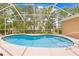 Beautiful, enclosed pool area surrounded by a screen enclosure and mature trees at 11284 Hickory Ridge Ct, Spring Hill, FL 34609