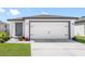 Charming single-story home featuring a spacious two-car garage, blue front door, and well-maintained landscaping at 116 Hallam Ct, Spring Hill, FL 34606