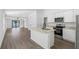 Bright, open kitchen featuring granite counters, white cabinets, stainless appliances, and seamless flow into the living area at 116 Hallam Ct, Spring Hill, FL 34606