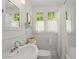 All-white bathroom with a vintage-style sink, black and white tile floor, and large window at 125 29Th N St, St Petersburg, FL 33713