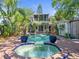 Backyard featuring a pool and jacuzzi with tropical landscaping and a two-story home at 125 29Th N St, St Petersburg, FL 33713