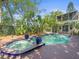 A refreshing pool and spa surrounded by lush tropical plants and a charming two-story home at 125 29Th N St, St Petersburg, FL 33713