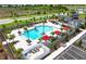 Aerial view of community pool area with sunshades, pool house and surrounding greenery at 17122 Moonflower Dr, Venice, FL 34293