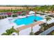 Stunning community pool featuring sunshades, seating, mature palms and lush landscaping at 17122 Moonflower Dr, Venice, FL 34293