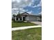 Charming single-story home featuring a well-manicured lawn, stone driveway, and neutral color scheme at 17122 Moonflower Dr, Venice, FL 34293